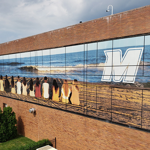 Large multi-pane outdoor graphic installed on buidling side.